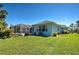 Exterior shot of backyard featuring a screen-in patio and beautiful landscaping at 1078 Boundary Blvd, Rotonda West, FL 33947