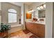 Bright bathroom features double sink vanity, bathtub with window and decorative plants at 1078 Boundary Blvd, Rotonda West, FL 33947
