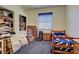Bedroom with blue carpet, small window, bed, and games at 1078 Boundary Blvd, Rotonda West, FL 33947