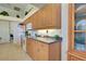 A kitchen featuring wood cabinets, tile floors, a white refrigerator, and countertops with a dark finish at 1078 Boundary Blvd, Rotonda West, FL 33947