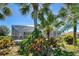 Backyard featuring a screened-in lanai, tropical foliage, and landscaping at 1078 Boundary Blvd, Rotonda West, FL 33947