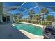 Private screened pool area featuring mature palm trees and sunny backyard vistas at 1078 Boundary Blvd, Rotonda West, FL 33947
