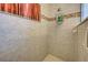 Tiled shower area showcasing showerhead, shelving, and patterned accent tiles at 1078 Boundary Blvd, Rotonda West, FL 33947