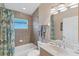 Bright bathroom featuring a shower with a floral curtain and tiled walls, along with a sink at 1080 Boundary Blvd, Rotonda West, FL 33947