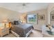 Comfortable bedroom with neutral tones, carpet, dresser, and a large window overlooking the pond at 1080 Boundary Blvd, Rotonda West, FL 33947