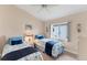 Comfortable twin bedroom featuring two beds with floral comforters, a ceiling fan, and natural light at 1080 Boundary Blvd, Rotonda West, FL 33947