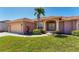 Front exterior featuring a well-manicured lawn with colorful plantings at 1080 Boundary Blvd, Rotonda West, FL 33947