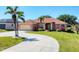 Charming home featuring a well-manicured lawn, decorative palms and a circular driveway at 1080 Boundary Blvd, Rotonda West, FL 33947