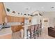 Bright kitchen featuring wooden cabinetry, an island with bar seating, and decorative shelving above at 1080 Boundary Blvd, Rotonda West, FL 33947
