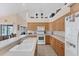 Well-lit kitchen boasts wooden cabinets, white appliances, tiled floors, and an island overlooking the backyard at 1080 Boundary Blvd, Rotonda West, FL 33947