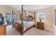 Cozy main bedroom with a four-poster bed, plush carpet, and access to the outdoor patio at 1080 Boundary Blvd, Rotonda West, FL 33947