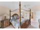 Elegant main bedroom with a decorative four-poster bed, neutral color palette, and two nightstands at 1080 Boundary Blvd, Rotonda West, FL 33947