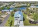 Aerial view of waterfront home with a metal roof, garage, and lush landscaping at 1141 Andrews St, Englewood, FL 34224
