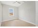An empty bedroom with light hardwood floors and a window overlooking neighborhood at 1141 Andrews St, Englewood, FL 34224