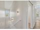 Bright hallway illuminated by decorative sconces and featuring a staircase at 1141 Andrews St, Englewood, FL 34224