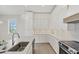 Bright kitchen showcasing white cabinetry, quartz countertops, and stainless steel appliances at 1141 Andrews St, Englewood, FL 34224