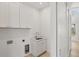 This laundry room features white cabinets, a sink and light wood floors at 1141 Andrews St, Englewood, FL 34224