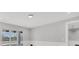 Bright living room with neutral paint, base molding and sliding glass door leading to a deck at 1141 Andrews St, Englewood, FL 34224