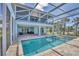 Back view of home featuring an enclosed pool and lounge seating at 1141 Andrews St, Englewood, FL 34224