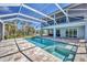 Rear elevation of home featuring a large enclosed pool and spa at 1141 Andrews St, Englewood, FL 34224