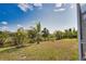 The grassy backyard leads to a canal, enhanced by tropical plants and trees at 116 Albatross Rd, Rotonda West, FL 33947