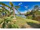Scenic backyard view featuring a serene lake and tropical landscaping at 116 Albatross Rd, Rotonda West, FL 33947