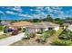 A well-maintained home with lush landscaping, an attached two-car garage, and a long driveway at 116 Albatross Rd, Rotonda West, FL 33947