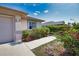 Charming home featuring beautiful landscaping with colorful bougainvillea bushes and a paved walkway to the entrance at 116 Albatross Rd, Rotonda West, FL 33947