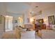 Spacious living room featuring neutral carpeting, a ceiling fan, and an entertainment unit with mounted television at 116 Albatross Rd, Rotonda West, FL 33947
