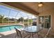 Covered patio with ceiling fan, dining table and chairs and a beautiful in-ground pool at 116 Albatross Rd, Rotonda West, FL 33947