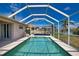 Refreshing in-ground pool with a screened enclosure and a view of the side and rear yard at 116 Albatross Rd, Rotonda West, FL 33947