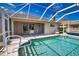 Back of home featuring patio, sparkling pool within screened enclosure and a lush, green yard at 116 Albatross Rd, Rotonda West, FL 33947