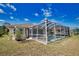 Home's back view featuring in-ground pool with enclosure and grassy yard, perfect for outdoor enjoyment at 116 Albatross Rd, Rotonda West, FL 33947