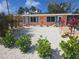 Charming bungalow with vibrant coral facade, complemented by turquoise shutters and meticulously arranged, low-maintenance landscaping at 1270 Gulf Blvd # A&B, Englewood, FL 34223