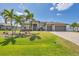 Beautifully landscaped home featuring a three-car garage and mature palm trees at 14527 Maysville Cir, Port Charlotte, FL 33981