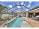 Inviting screened pool area with lush landscaping, perfect for outdoor relaxation and entertaining at 14527 Maysville Cir, Port Charlotte, FL 33981