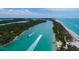 Aerial view of a clear waterway near pristine beaches with vibrant green trees and multiple boats enjoying the scenery at 1551 Beach Rd # 412, Englewood, FL 34223