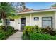 Community clubhouse exterior featuring stucco walls, a dark door, windows and manicured landscaping at 1551 Beach Rd # 412, Englewood, FL 34223