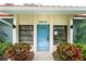 Community clubhouse entrance featuring a light blue door, manicured landscaping, and tile roof at 1551 Beach Rd # 412, Englewood, FL 34223