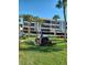 Well-maintained apartment building with palm trees, a grilling area, and community green space at 1551 Beach Rd # 412, Englewood, FL 34223