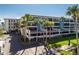 Multi-story condominium complex featuring balconies, assigned covered parking, and mature palm trees at 1551 Beach Rd # 412, Englewood, FL 34223