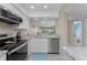 Modern kitchen with stainless steel appliances, granite countertops, and views of the living area at 1551 Beach Rd # 412, Englewood, FL 34223