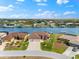 Aerial view of a home on the water with a dock, surrounded by other homes and lush greenery, all under a clear blue sky at 15588 Ruston Cir, Port Charlotte, FL 33981