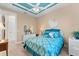 Charming bedroom with blue accents, featuring bright walls, and a ceiling fan at 15588 Ruston Cir, Port Charlotte, FL 33981
