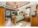 A well-lit primary bedroom with a decorative ceiling fan, a large bed, and access to the patio at 15588 Ruston Cir, Port Charlotte, FL 33981