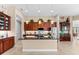 Modern kitchen with stainless steel appliances, sleek countertops, dark wood cabinets, and a stylish island with pendant lighting at 15588 Ruston Cir, Port Charlotte, FL 33981