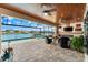 Outdoor living area overlooking the lake, featuring a pool, a fire pit and ample seating at 15588 Ruston Cir, Port Charlotte, FL 33981