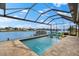 Stunning waterfront pool with covered lanai, offering a picturesque view of the surrounding water at 15588 Ruston Cir, Port Charlotte, FL 33981