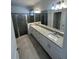 Modern bathroom with double sinks, granite countertops, and a glass-enclosed shower at 15968 Honeysuckle St, Port Charlotte, FL 33953
