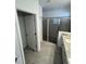 Bathroom featuring a glass-enclosed shower, tile floors, and access to extra storage at 15968 Honeysuckle St, Port Charlotte, FL 33953